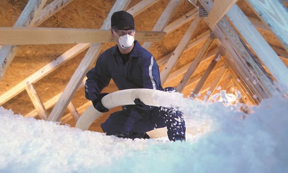 Artisan Robert Jean Jacques réalisant une isolation de combles par soufflage dans une maison dans l'Essonne.<br>